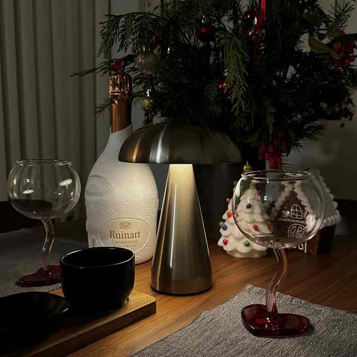 Silver-tone mood lamp and Christmas decorations set on a wood-toned dining room table