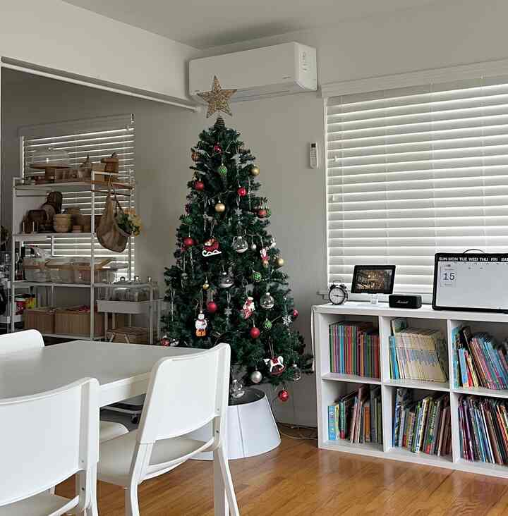 Natural and cozy living and dining room in white and brown tones featuring a decorated Christmas tree