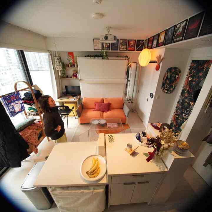 White and orange-toned studio apartment featuring compact layout with home office in a minimal living room space