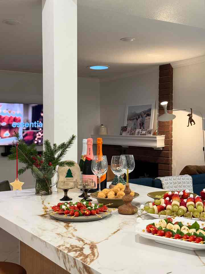 White and brown toned kitchen space featuring party food and drinks with a cozy home party atmosphere
