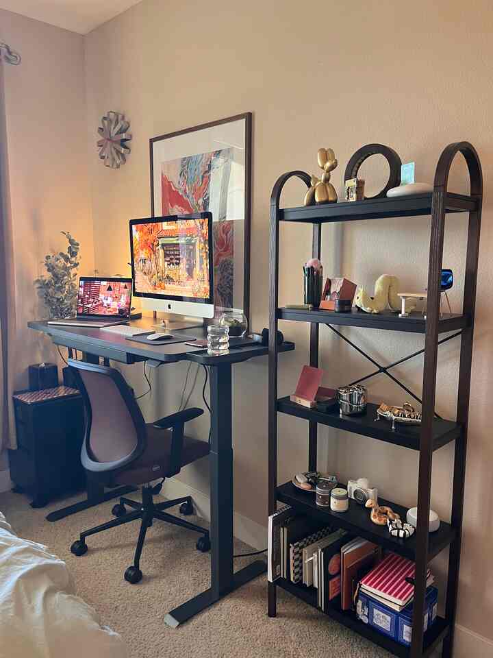 Warm beige home office featuring wood-toned shelving, desk with chair, and cozy atmosphere