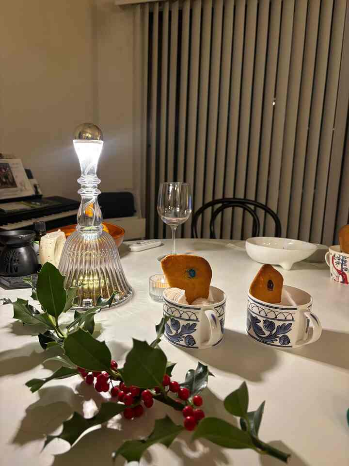 White-toned dining room featuring a silver lamp and cups on the table, creating a cozy home party atmosphere