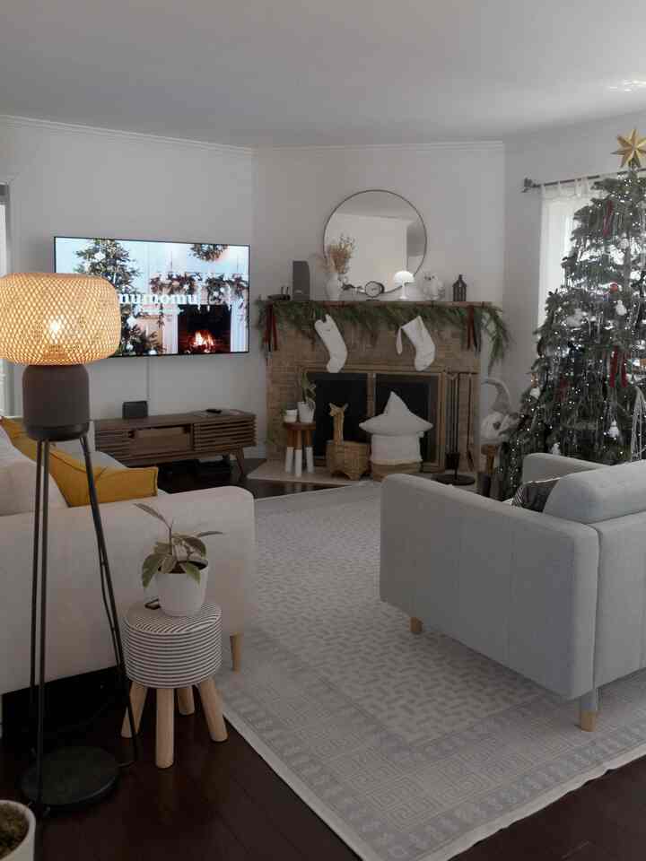White and gray toned Nordic living room featuring a Christmas tree and fireplace with a cozy atmosphere