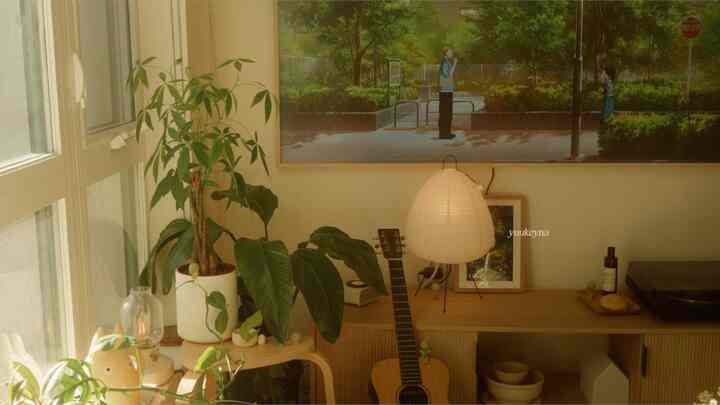 Natural color toned living room featuring a wooden console table, plants, guitar, and a table lamp in a cozy arrangement