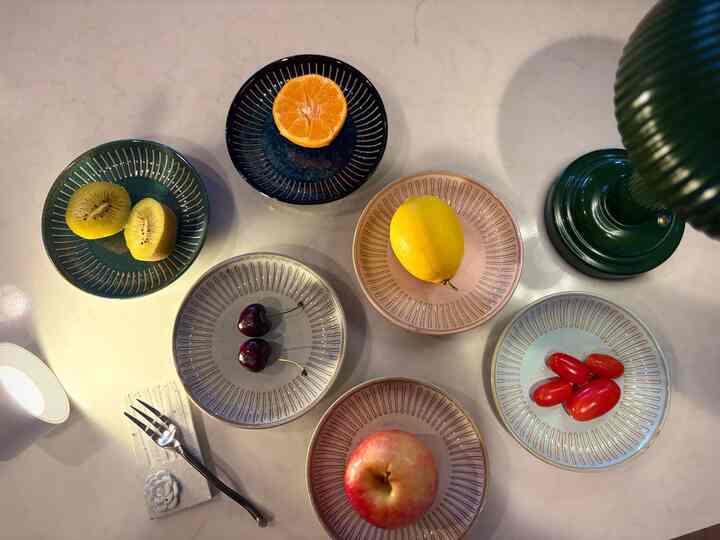 Simple practical table setting with several small side plates in soft natural tones arranged with fresh fruits