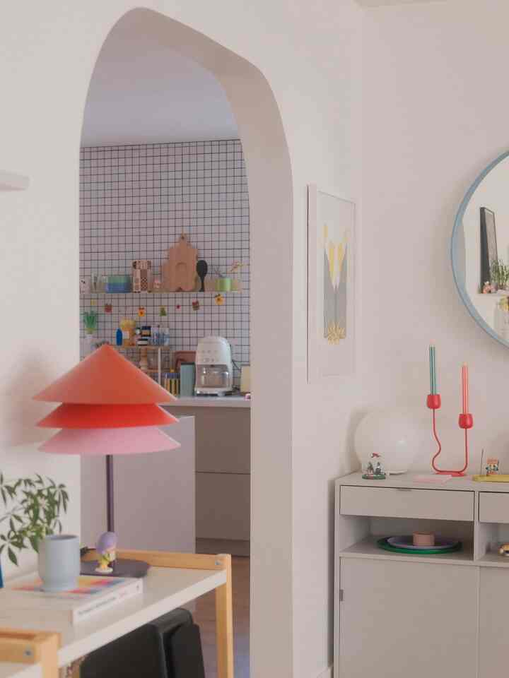 White and red toned kitchen and living room corner featuring corner storage and minimalist lighting elements