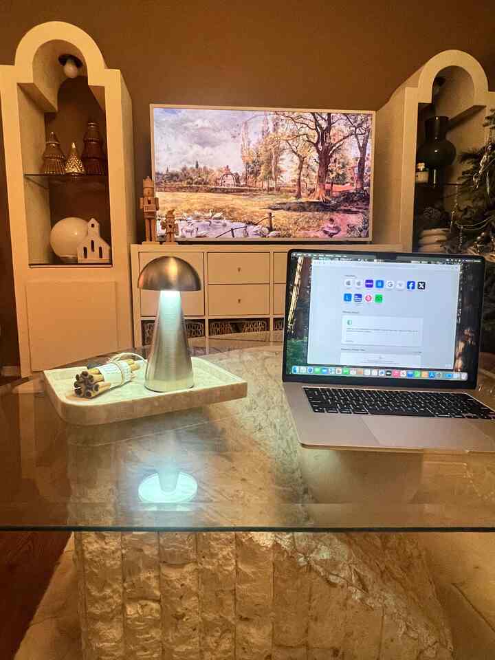 Beige-toned walls and marble table in a mid-century modern home office space, featuring a silver mushroom table lamp and a neatly placed laptop