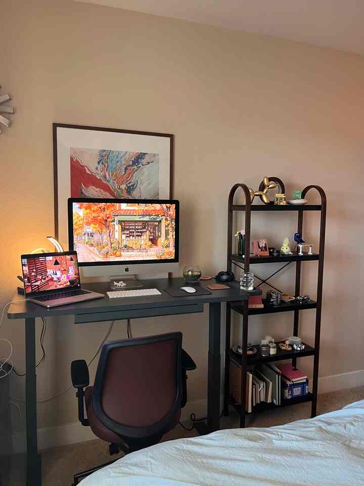 Warm brown-toned home office space featuring a monitor, laptop, office chair, and shelving unit in a cozy work area