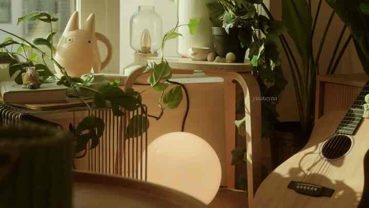 Warm gold-toned natural wood living room featuring plants and soft lighting creating a cozy atmosphere