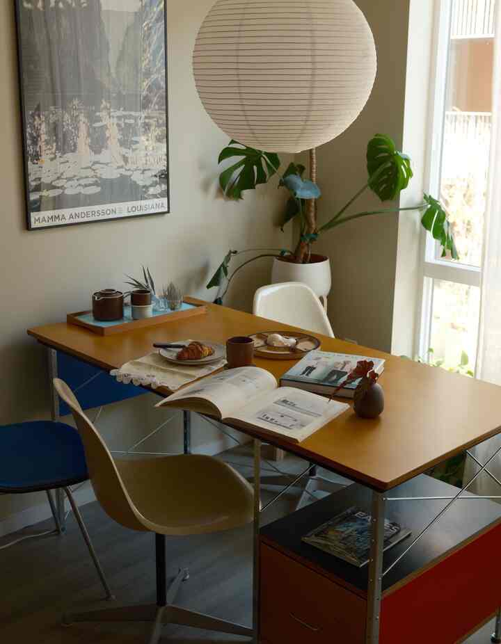 Natural beige and wood-tone studio apartment dining space featuring coffee and croissant on table, cozy home cafe atmosphere