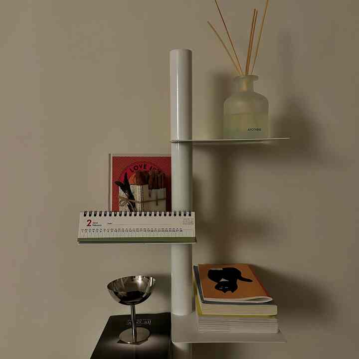 White-toned bookshelf featuring books, candle, and diffuser accessories arranged neatly in a minimal and cozy vibe