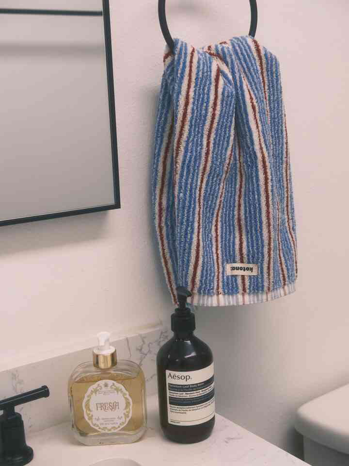 White and black toned bathroom featuring Kotona hand towel and elegant dispensers with a clean atmosphere