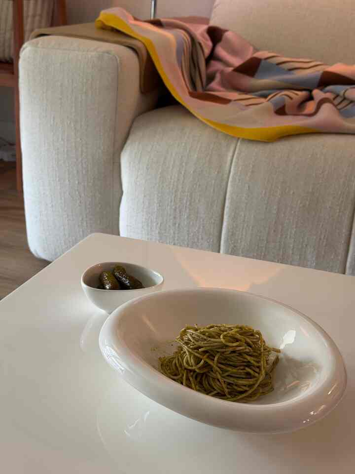 Beige sofa and white coffee table with multicolor throw blanket in a simple living room setting