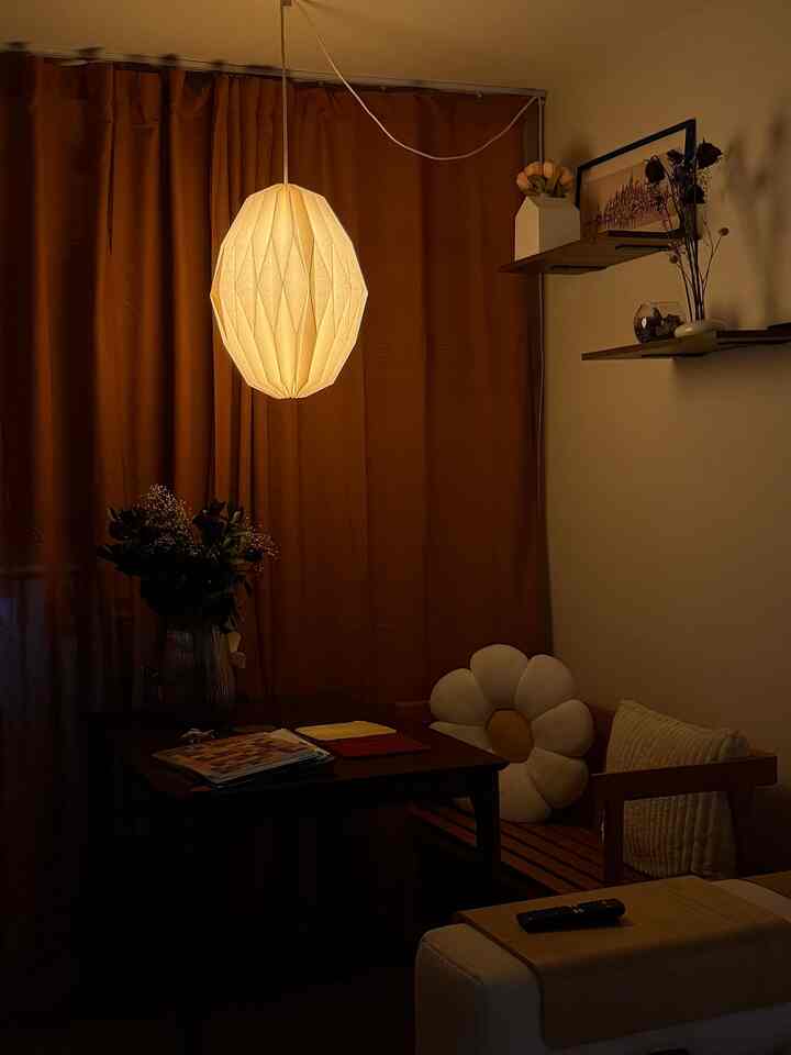 Cozy living room with warm brown curtains and white pendant lighting creating a comforting atmosphere
