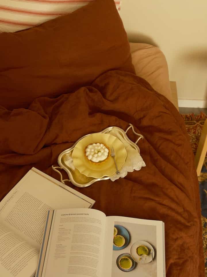 Cozy bedroom in warm brown and beige tones featuring brown bedding and a yellow plate on a silver tray