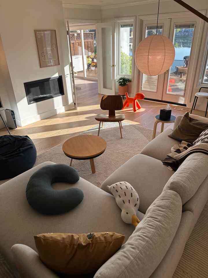 Natural-toned modern living room featuring large windows and pet toy with cozy atmosphere