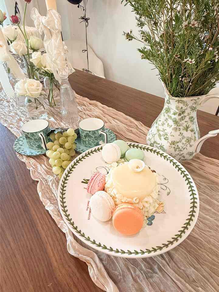 Beige and green toned dining space featuring floral pitcher, vintage-style plate and teacups with a soft, romantic home cafe vibe