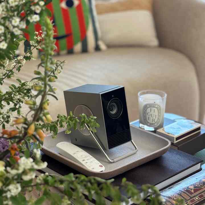 Beige-toned living room featuring LG projector and candle on a coffee table, creating cozy atmosphere
