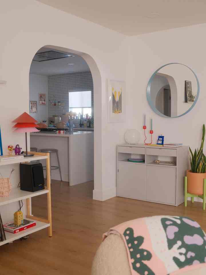 White and wood tone archway interior featuring living room and kitchen with a modern, clean atmosphere