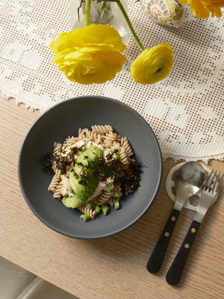Natural wood tone dining table featuring white lace table runner and black-handled cutlery for a casual quick lunch