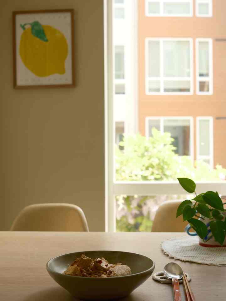 Beige and wood tone dining room featuring dining table, chairs, and a bowl of food creating a cozy atmosphere