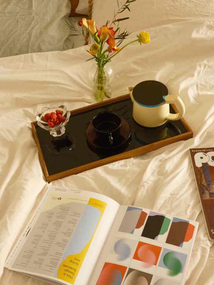 White-toned bedroom featuring a tray with tea set and vase centrally placed, creating a cozy atmosphere